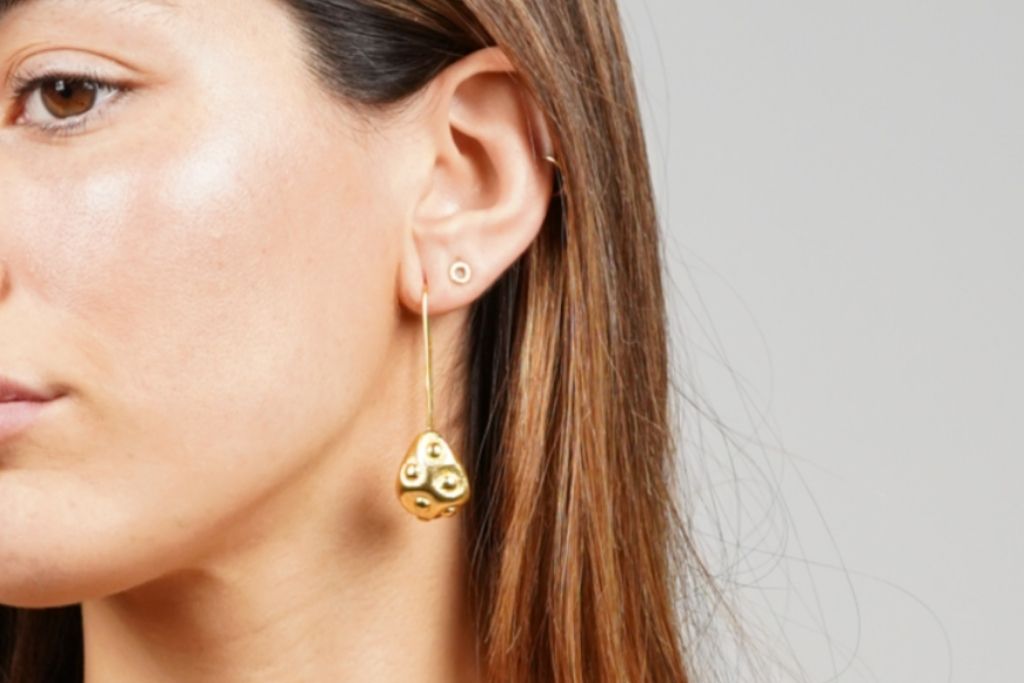 Tipos de pendientes combinados: aro pequeño y pendiente largo dorado
